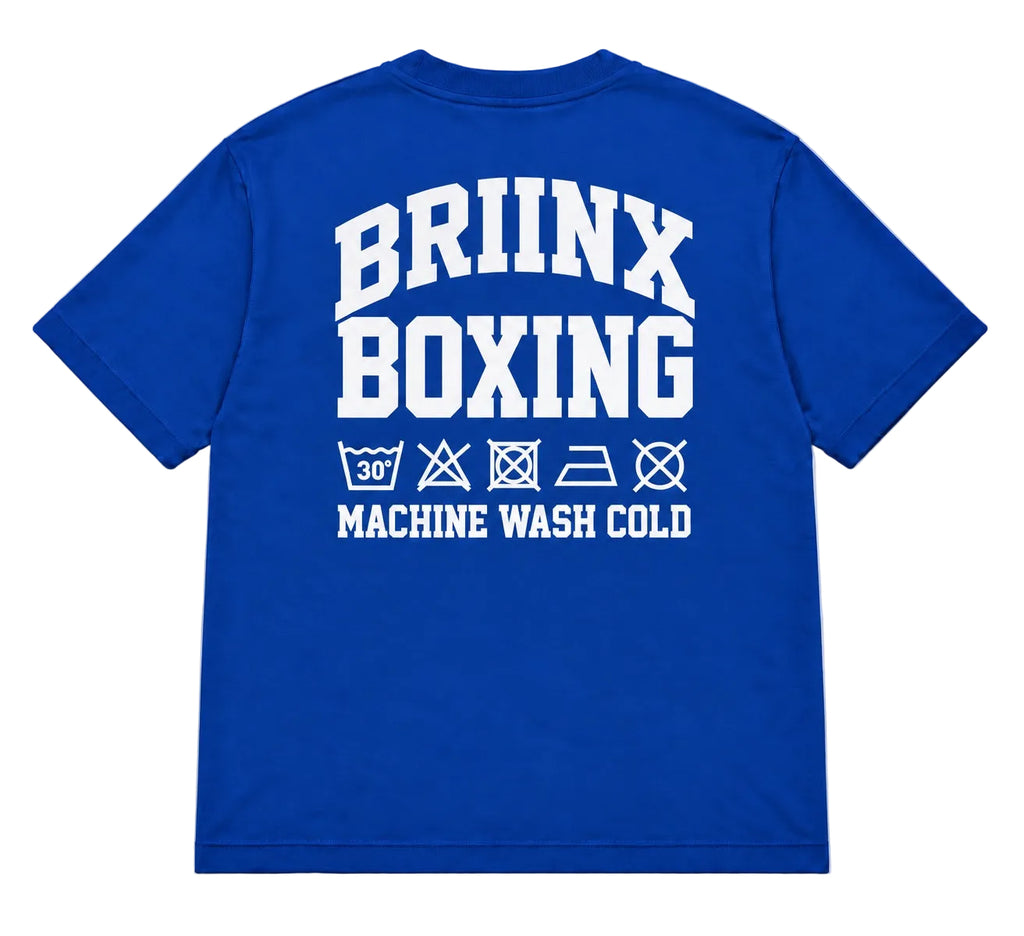 A royal blue short-sleeve t-shirt shown from the back, featuring a large white graphic print that reads 'BRIINX BOXING' with laundry care symbols and 'MACHINE WASH COLD' underneath, laid flat on a light gray background.