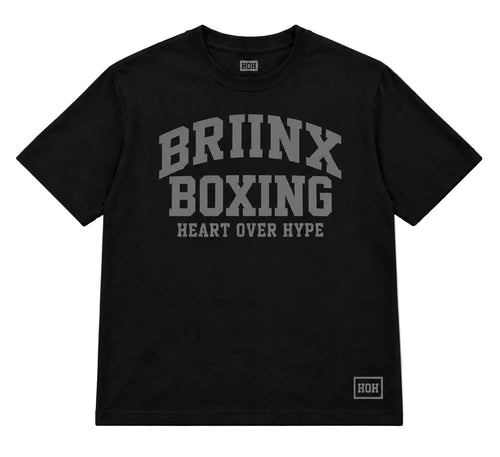 A black short-sleeve t-shirt with a gray graphic print on the front reading 'BRIINX BOXING HEART OVER HYPE' and a small 'HOR' logo near the bottom right hem, shown on a light gray background.