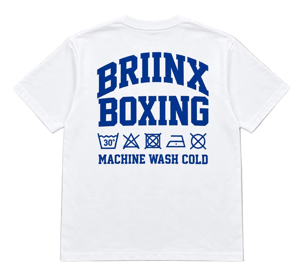 White short-sleeve t-shirt shown from the back, featuring a bold blue graphic print that reads 'BRIINX BOXING' with laundry care symbols and 'MACHINE WASH COLD' underneath, set against a neutral gray background.